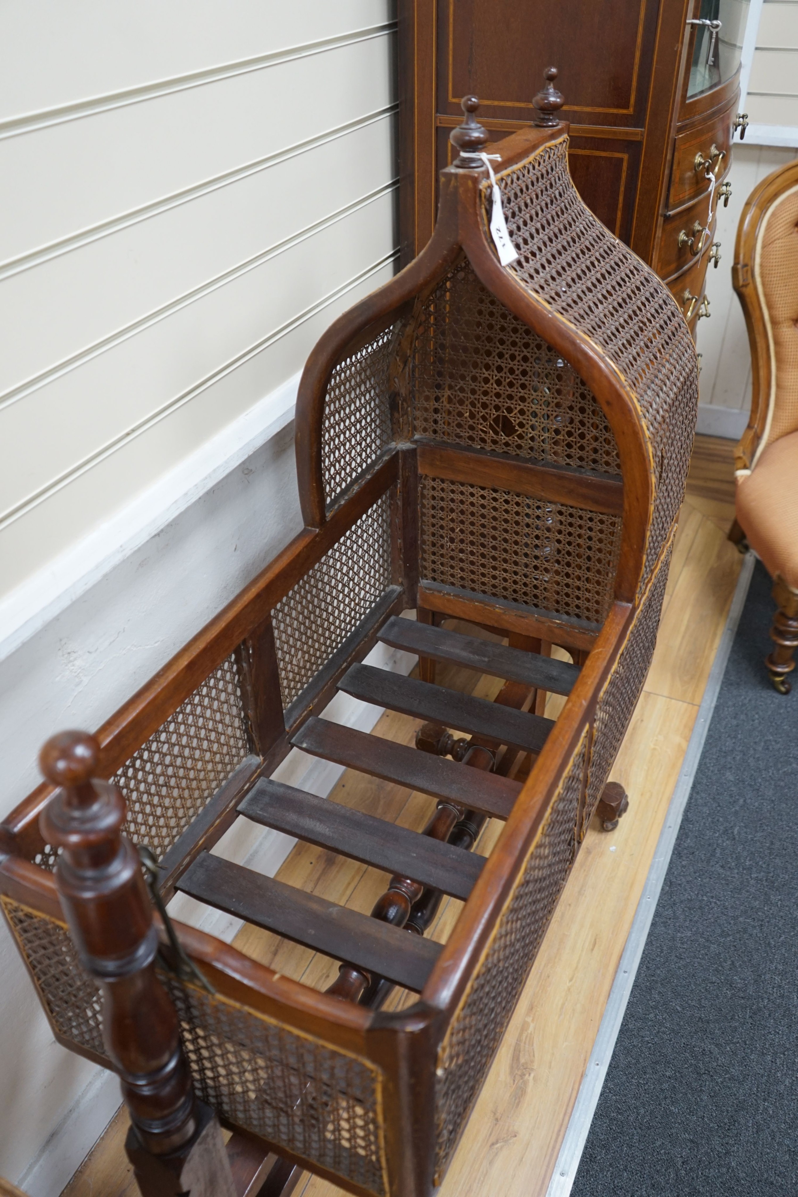 A Victorian caned mahogany rocking cradle with arched canopy, width 100cm, depth 41cm, height 124cm